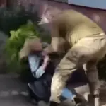 Військовий ТЦК відштовхує жінку, яка розпилила сльозогінний газ під час роботи групи оповіщення на вулиці Дунайській у